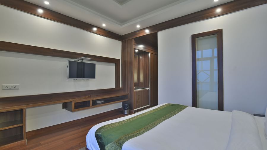 A view of the bed in front of a TV in a Premium Room at DLS Highland Resort and Spa, Mussoorie.